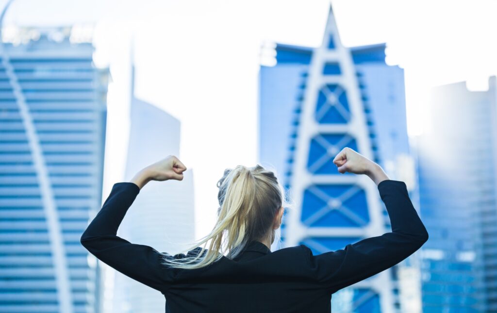 Empowered woman in strong stance overlooking cityscape